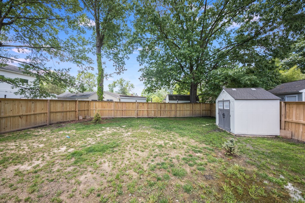Privacy fenced back yard with storage shed